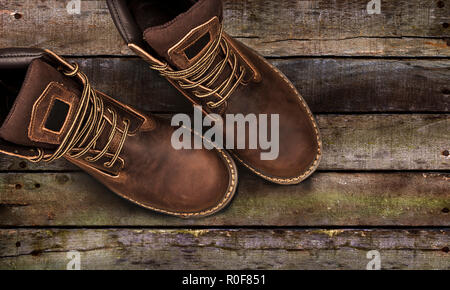 Braun Herren stiefel, auf einer hölzernen Hintergrund. Closeup isoliert Stockfoto
