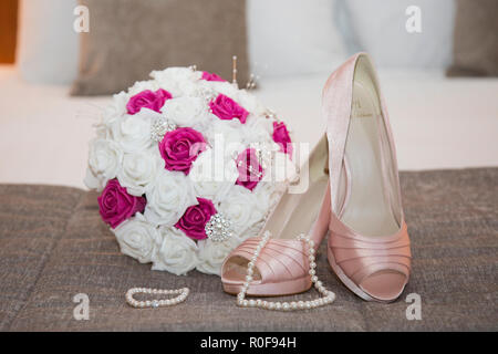 In der Nähe von Brides Bouquet, Schuhe und Perlenkette bereit an Ihrem Hochzeitstag getragen zu werden. Stockfoto