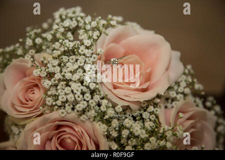 Brides Bouquet von weißen Blumen und Rosen mit Diamond Engagement Ring sitzen auf die Blütenblätter der Rose Stockfoto