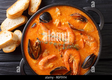 Katalanisch authentische würzige Suquet de Peix Suppe mit Kartoffeln, Krabben, Muscheln, Kräuter und Fisch mit picad Close-up in einer Pfanne auf dem Tisch. horizontal oben Stockfoto