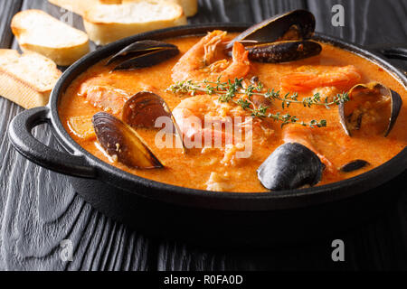 Katalanisch authentische würzige Suquet de Peix Suppe mit Kartoffeln, Krabben, Muscheln, Kräuter und Fisch mit picad Close-up in einer Pfanne auf dem Tisch. Horizontale Stockfoto