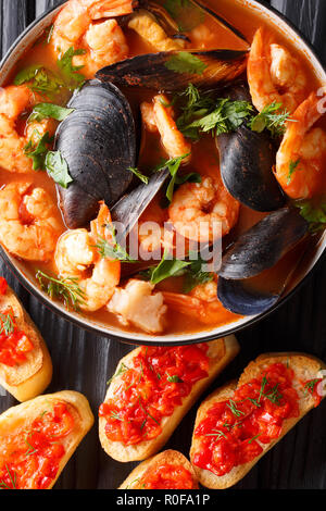 Französische Bouillabaisse Fischsuppe mit Garnelen, Fischfilets und Muscheln closeup in einer Schüssel auf den Tisch. Vertikal oben Ansicht von oben Stockfoto