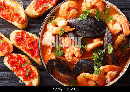 Französische Bouillabaisse Fischsuppe mit Garnelen, Fischfilets und Muscheln closeup in einer Schüssel auf den Tisch. horizontal oben Ansicht von oben Stockfoto