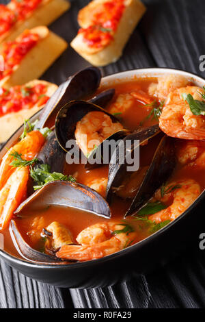 Leckere Tomatensuppe mit Krabben Bouillabaisse, Fischfilets und Muscheln closeup in einer Schüssel auf dem Tisch. Vertikale Stockfoto