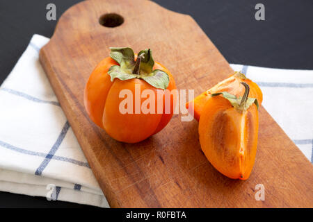 Frische Dattel auf Holzbrett über schwarzen Hintergrund, Seitenansicht. Close-up. Stockfoto