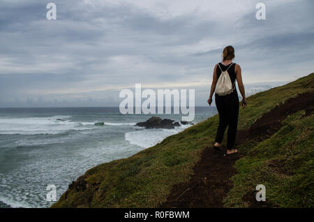 Frau klettern Hügel bei Seger Strand und Blick auf den Ozean, Lombok. Stockfoto