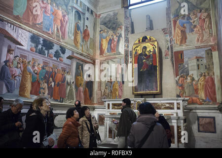 Touristen besuchen die Brancacci Kapelle (Cappella Brancacci) in der Kirche von Santa Maria del Carmine in Florenz, Toskana, Italien. Fresken von italienischen Renaissance Maler Masaccio und Masolino da Panicale (1420-1427) abgeschlossen von Filippino Lippi (1485) sind im Hintergrund zu sehen. Stockfoto