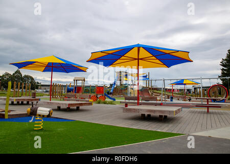 Große Sonnenschirme spenden Schatten an einer Stadt Spielplatz für Kinder Stockfoto