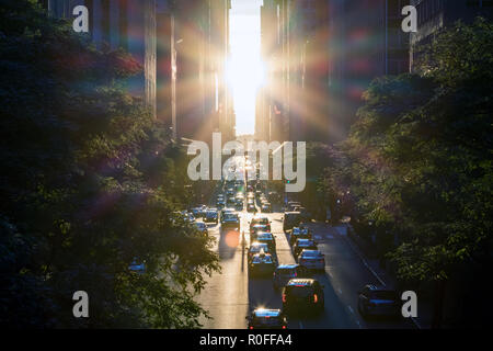 Sonnenstrahlen leuchten auf den Autos und Gebäude entlang der 42th Street, in Midtown New York City Stockfoto