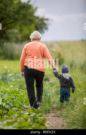 Großmutter, die ihren Enkel zur Orchard für die Inspektion Stockfoto