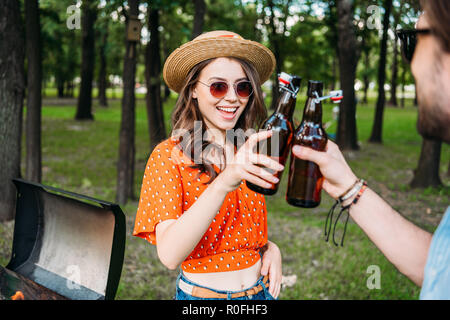 Teilweise mit Blick auf die paar klirrenden Flaschen Bier während der Grill im Park Stockfoto