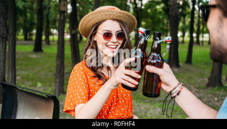 Teilweise mit Blick auf die paar klirrenden Flaschen Bier während der Grill im Park Stockfoto