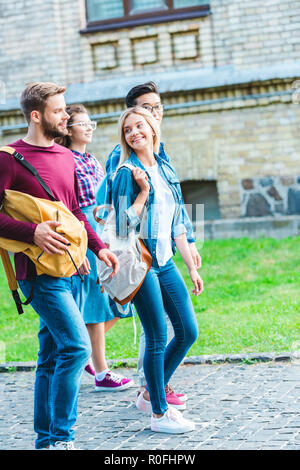 Gruppe von Multiethnischen Studenten mit Rucksäcken walking im Park Stockfoto