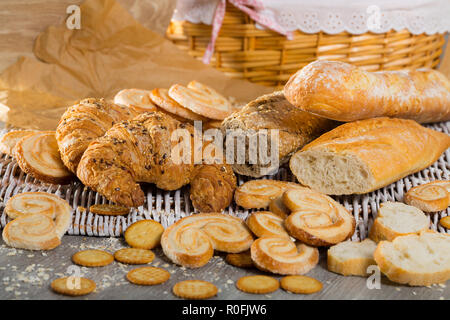 Frisch gebackenen Weizen und Korn Baguettes, Croissants und Keksen auf wicker Hintergrund Stockfoto