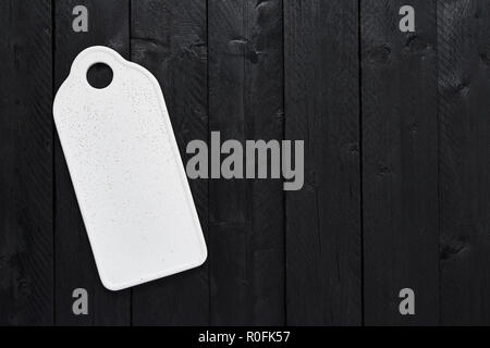 Blick von oben auf die weißen, eleganten Servierteller auf schwarzer Holztisch mit kopieren. Stockfoto