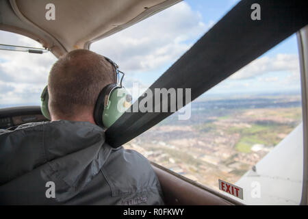 Co Pilot in einem Piper PA-28 Cherokee Leichtflugzeug aus Northumbria Flugschule, Flughafen Newcastle, Tyne fliegen und Verschleiß, Großbritannien Stockfoto
