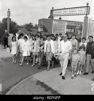 1967, historische, eine Gruppe von Eltern und Jugendlichen sammeln vor dem Eingang zu Quarrendon County Seconary der Schule, einer neuen post-secondary school in der modernen "brutalist" Design der Zeit gebaut. Es wurde von der Herzog von Edinburgh im Jahre 1958 eröffnet. Die Schule ist nun eine Kirche von England Academy. Stockfoto