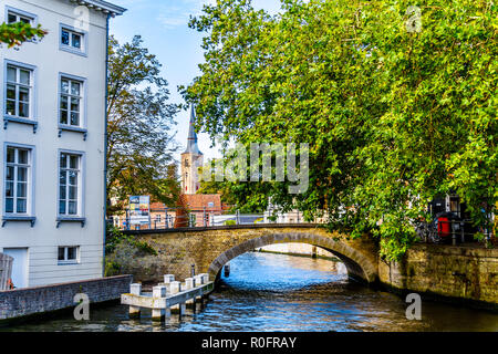 Steinerne Brücke an der Hoogstraat vom Groenerei und Wollestraat Kanäle von Brügge, Belgien mit der St. Anna Kirche Turm im Hintergrund Stockfoto