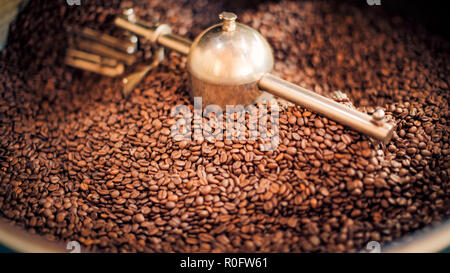 Kaffeeröster, frisch geröstete Kaffeebohnen Hintergrund Stockfoto