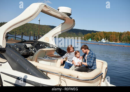 Familie mit Tochter gemeinsam Urlaub auf Segelboot in See Stockfoto