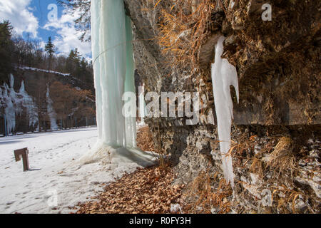 Gefrorenen Wasserfällen auf einer Klippe in Watkins Glen State Park, Watkins Glen, im Staat New York an einem sonnigen, aber kalten Wintertag. Stockfoto