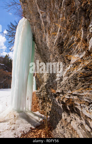 Gefrorenen Wasserfällen auf einer Klippe in Watkins Glen State Park, Watkins Glen, im Staat New York an einem sonnigen, aber kalten Wintertag. Stockfoto