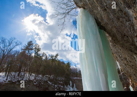 Gefrorenen Wasserfällen auf einer Klippe in Watkins Glen State Park, Watkins Glen, im Staat New York an einem sonnigen, aber kalten Wintertag. Stockfoto