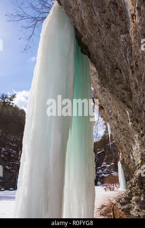 Gefrorenen Wasserfällen auf einer Klippe in Watkins Glen State Park, Watkins Glen, im Staat New York an einem sonnigen, aber kalten Wintertag. Stockfoto