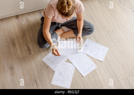 Junge Hausfrau Ausgaben tome auf Papier Stockfoto