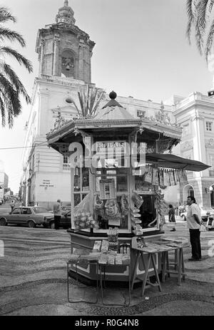 Ein Kiosk auf der Plaza De San Juan de Dios, Cadiz, Spanien. Dahinter befindet sich die Iglesia de San Juan de Dios Stockfoto