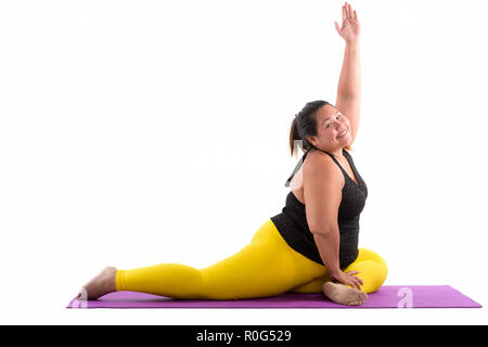 Studio shot der Jungen gerne Fett asiatische Frau lächelnd während Stretch Stockfoto