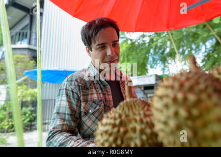 Attraktive touristische Mann kaufen Durian Frucht in Street Shop Stockfoto