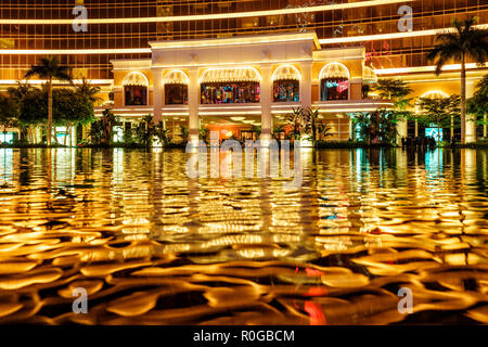 Macau, China - Januar 24, 2016: Wynn Macau Palace Eingang Gruppe nacht Ansicht zeigt Wasser Reflexionen der architektonischen Beleuchtung auf der Oberfläche o Stockfoto