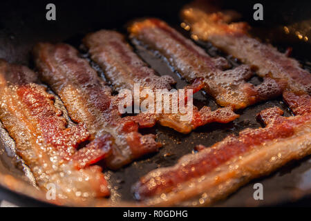 Speck Streifen oder speckscheiben in der Pfanne in den Strahlen der Sonne gekocht. Close-up Stockfoto