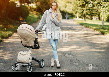 Junge Mutter mit dem Kinderwagen schieben Stockfoto