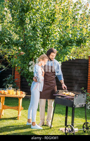 Lächelndes Paar Grill auf Hinterhof auf Sommer Tag Stockfoto