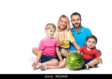 Glückliche Eltern mit Kindern und Wassermelone isoliert auf weißem Stockfoto