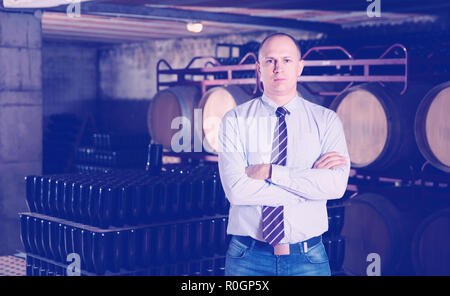 Sicher froh, heiter erfolgreiche Mann Winzer im eigenen Weingut vault Posing Stockfoto