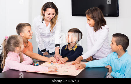 Russische Kinder bewegen sich auf Vormarkierte Oberfläche des Brettspiels im Klassenzimmer Stockfoto