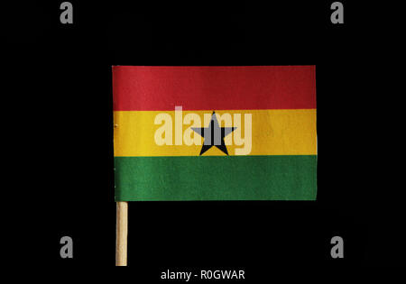 Eine nationale Flagge Ghana auf Zahnstocher auf schwarzem Hintergrund. Eine horizontale Triband von Rot, Gold und Grün mit einem schwarzen Stern in der Mitte. Stockfoto