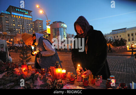 Januar 26, 2014 - Kiew, Ukraine: regierungsfeindlichen Demonstranten Licht einer Kerze in ein improvisiertes Mahnmal im Kiewer Platz der Unabhängigkeit, wie sie trauern die Demonstranten von der Polizei in den letzten Auseinandersetzungen Rassemblement sur la place de l'Independance ein Kiew, connue comme le Maidan, Tandis que Les Rues avoisinantes sind herissees de Barrikaden getötet. *** Frankreich/KEINE VERKÄUFE IN DEN FRANZÖSISCHEN MEDIEN *** Stockfoto