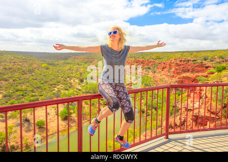 Blond kaukasische Frau mit offenen Armen genießt die Murchison River Gorge Ansichten von Hawks Head Aussichtspunkt in Kalbarri Nationalpark, Western Australia. Gerne weibliche Reisen im Outback Australiens. Stockfoto