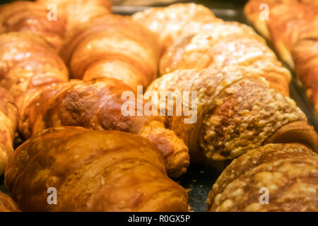 Eine Reihe von appetitlich ruddy Croissants auf ein Fach in einem Showcase Stockfoto