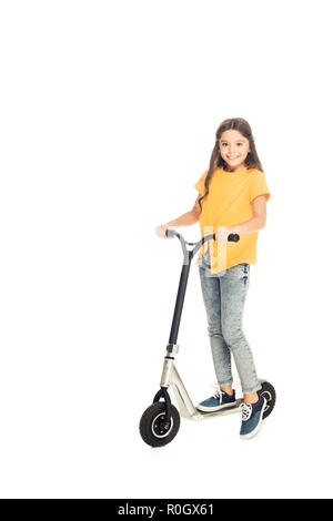 Adorable glückliches Kind reiten Roller und lächelnd an Kamera isoliert auf weißem Stockfoto