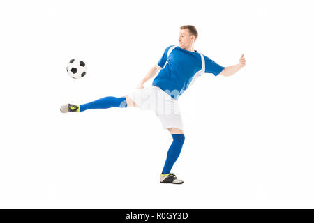 In voller Länge ansehen der athletischen jungen Fußballspieler treten isoliert auf weißem Ball Stockfoto