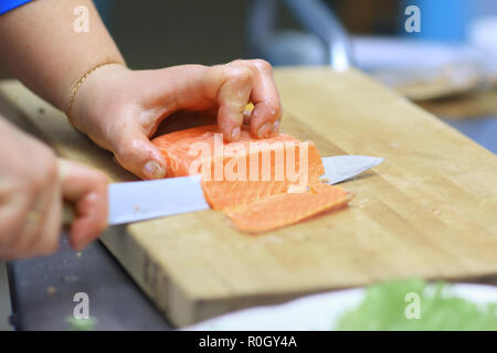 Bis zu schließen. Küchenchef schneiden Fisch für Sushi Stockfoto