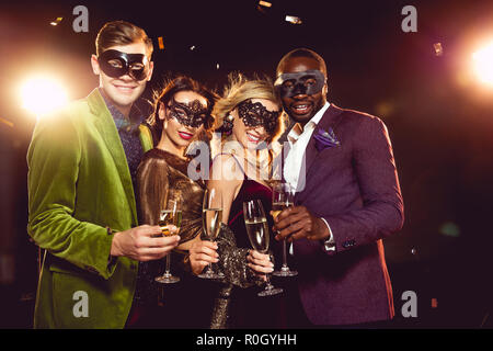 Luxus multiethnischen Freunde im Karneval Masken feiert das neue Jahr mit Sekt Gläser Stockfoto