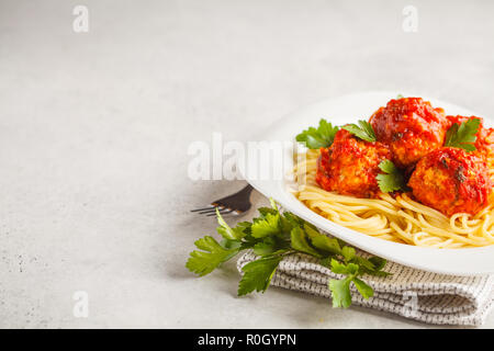 Huhn Hackfleischbällchen mit Tomatensauce und Spaghetti in eine weiße Platte, weisser Hintergrund. Stockfoto