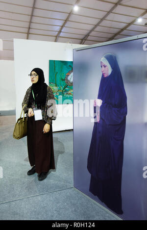 Nord afrikanische Frau, die traditionelle Kleidung und jihab Besuch einer Ausstellung zeitgenössischer Kunst in Marrakesch Nordafrika Stockfoto