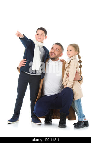 Stilvolle Vater umarmt Kinder im Herbst Outfit, Junge, etwas isoliert auf weißem Stockfoto
